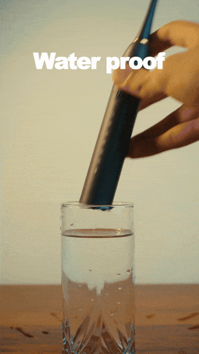Waterproof electric toothbrush being dipped in water to show durability